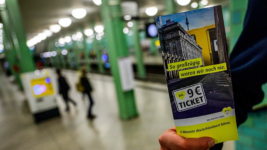 an employee of Berlin's public transport company (BVG) shows flyers he is making available to commuters explaining the so-called '9-euro-ticket' in the Alexandeplatz U-bahn subway station in Berlin. Credit: AFP File Photo