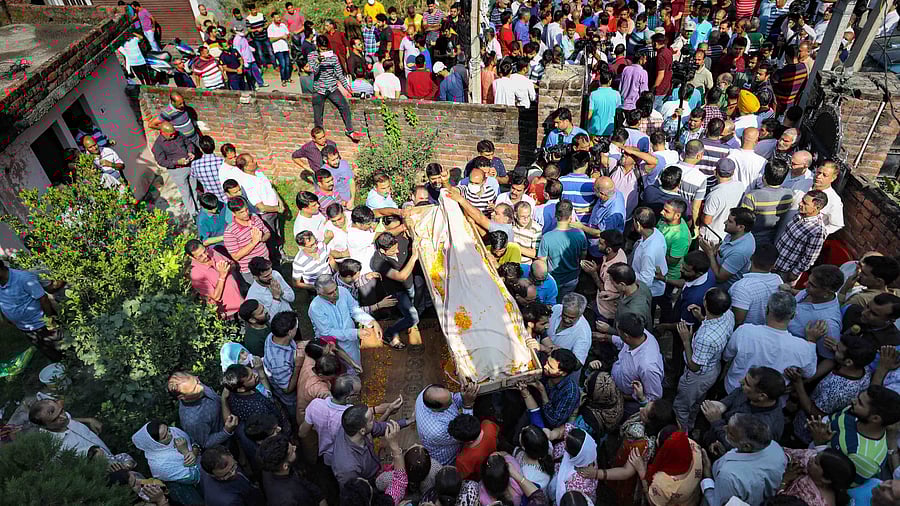 Family members and relatives of Puran Krishan Bhat, a Kashmiri Pandit who was shot dead allegedly by militants in Shopian. Credit: PTI Photo