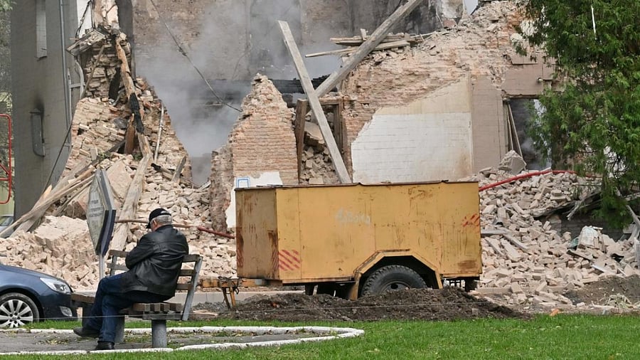 A local resident sits outside a building destroyed by Russian, Iranian-made, drones after an airstrike on Bila Tserkva, southwest of Kyiv, on October 5. Credit: AFP Photo