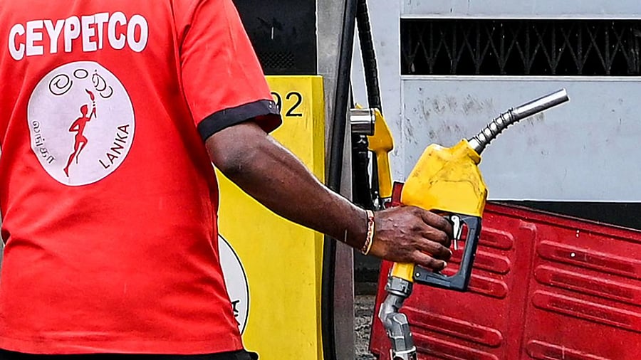 An employee fills petrol in an auto rickshaw in Colombo. Credit: AFP Photo