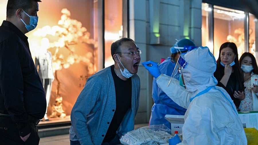 A health worker takes a swab sample from a man to test for the Covid-19 in Shanghai. Credit: AFP Photo