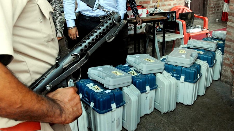 A policeman keeps guard sets of VVPAT machines and EVMs. Credit: PTI File Photo