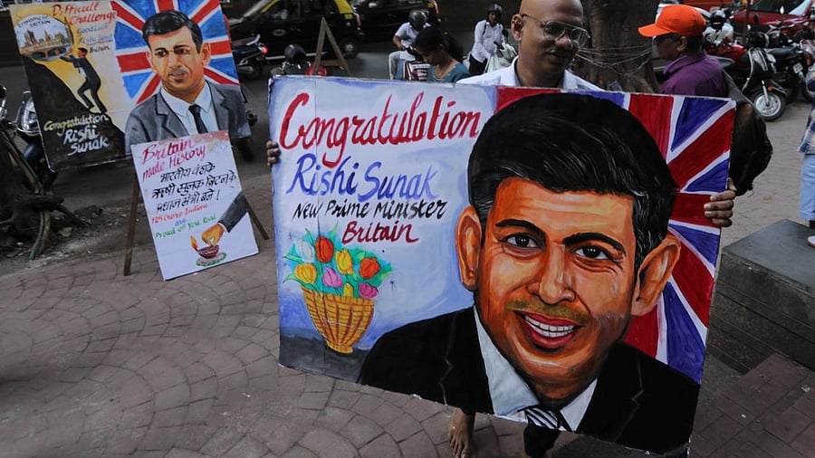 An artist carries a painting of Britain's new PM Sunak, in Mumbai. Credit: Reuters Photo