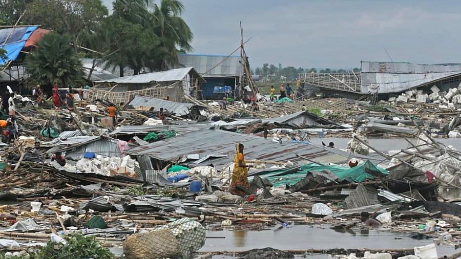 People search for their belongings amid debris in the aftermath of cyclone Sitrang hitting Bangladesh. Credit: AFP Photo