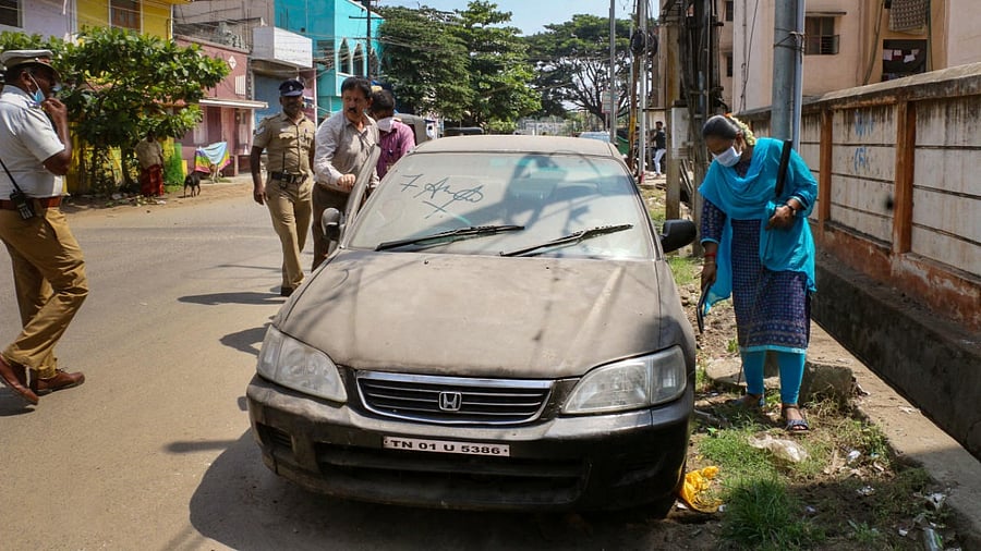 Security personnel check a parked vehicle after an LPG cylinder exploded inside a car recently, in Coimbatore. Credit: PTI Photo