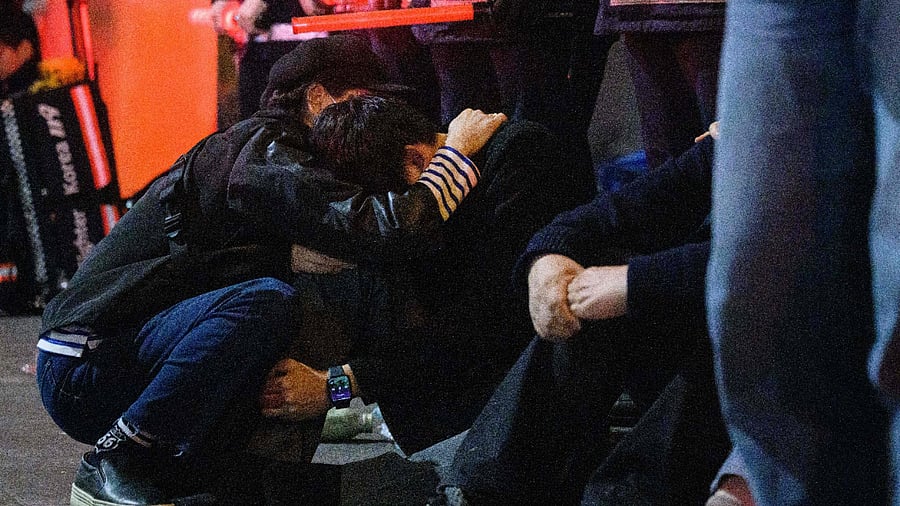 People comfort each other after a stampede at a packed Halloween event in central Seoul, early on October 30. Credit; AFP Photo