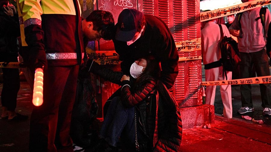 A woman is attended to as dozens of people suffered cardiac arrest in the popular nightlife district of Itaewon in Seoul. Credit: AFP Photo