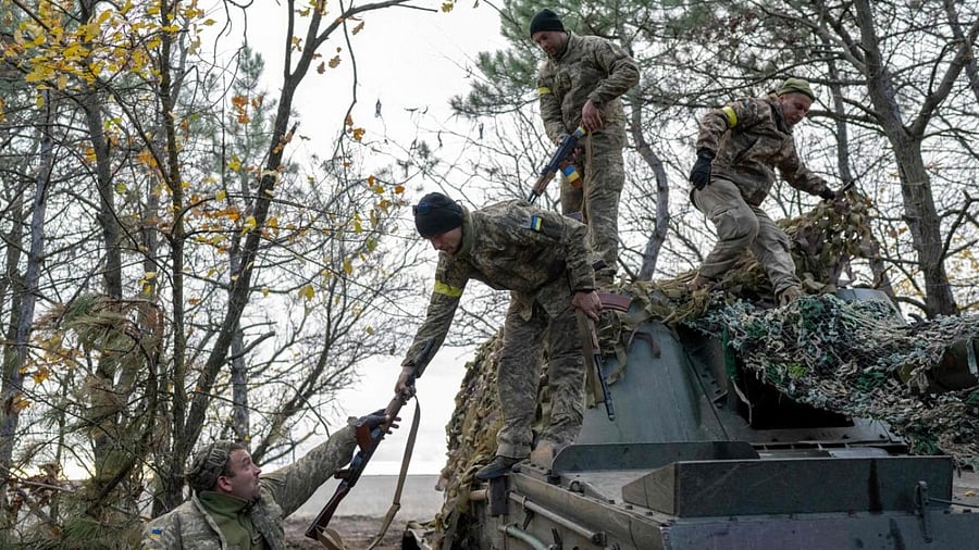 Ukrainian artillery unit members turn back to their position after fire towards Kherson. Credit: AFP Photo