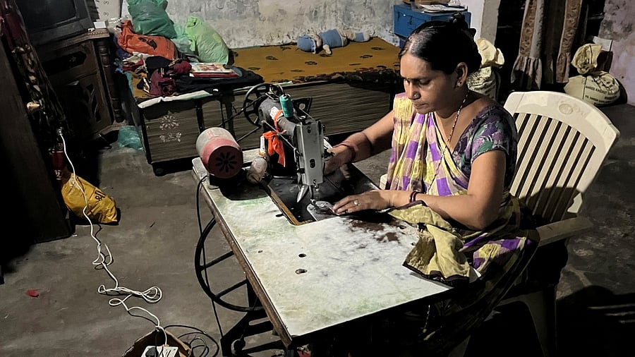 Reena Ben works on a solar-powered sewing machine to stitch clothes inside her one-room house in Modhera, India's first round-the-clock solar-powered village, in the western state of Gujarat, India, October 19, 2022. Credit: Reuters Photo