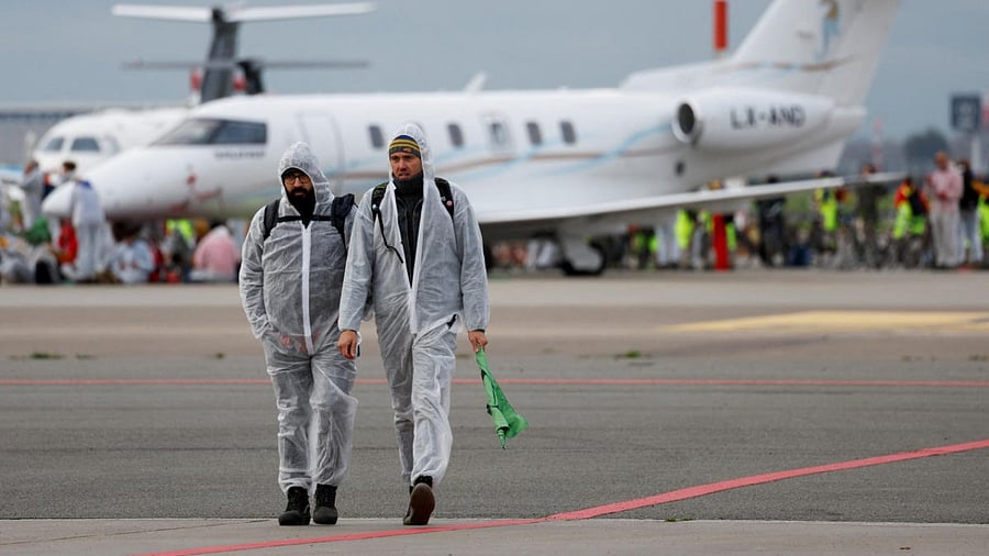 Climate activists walk during a protest against environmental pollution from aviation at Amsterdam's Schiphol Airport, in Schiphol. Credit: Reuters photo