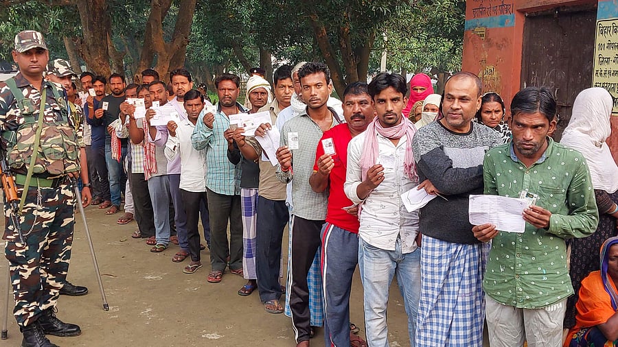 Voters holding their identification cards stand in a queue to cast their votes for the Gopalganj Assembly by-elections, in Gopalganj, Bihar, Thursday, Nov. 3. Credit: PTI Photo