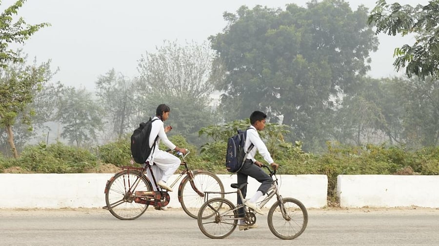  Students cycle to school amid heavy smog, near Vaidpura village in Gautam Buddha Nagar district. Credit: PTI Photo