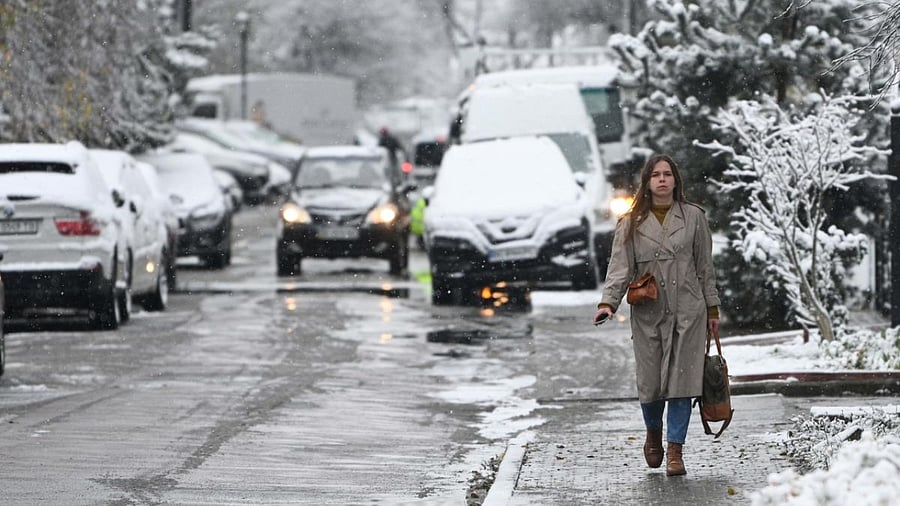 A pedestrian walks during first snow fall in the western Ukrainian city of Lviv, on November 17, 2022, amid the Russian invasion of Ukraine. Credit: AFP Photo