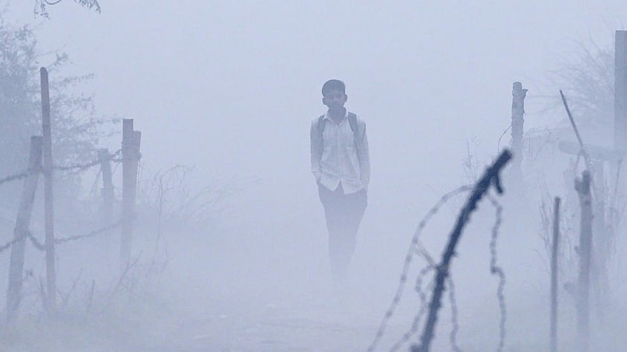 A student walks in an open field area shrouded in smog in New Delhi, Tuesday, Nov. 8, 2022. Credit: PTI Photo