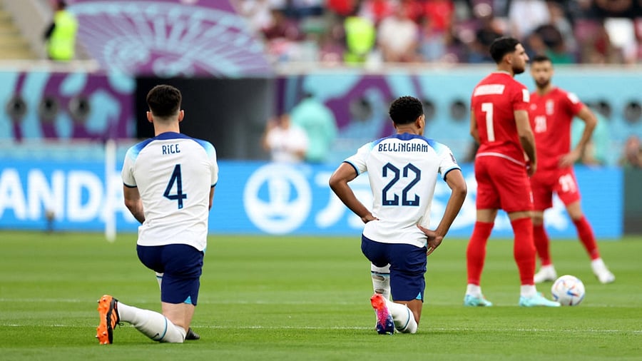 England's Declan Rice and Jude Bellingham take a knee before the match against Iran. Credit: Reuters Photo