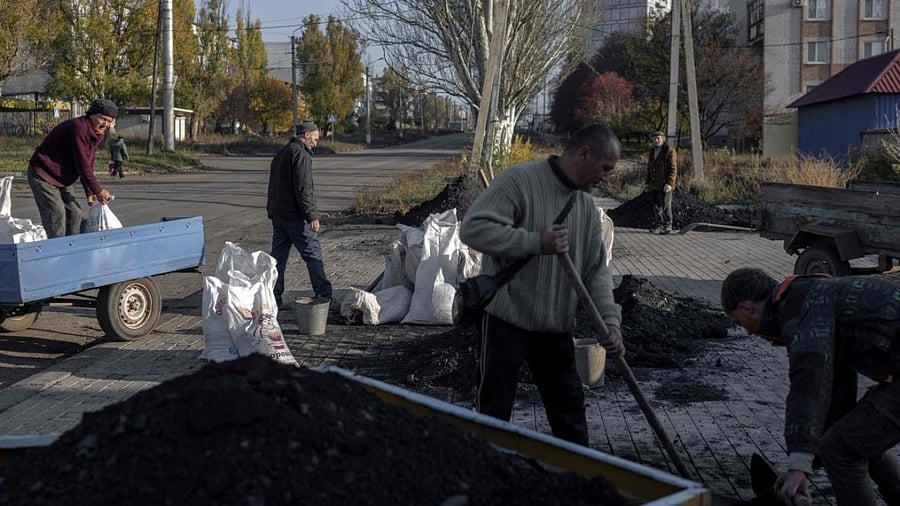 Ukrainian residents load a small truck with coal to distribute among people for the winter preparations. Photo Credit: AFP
