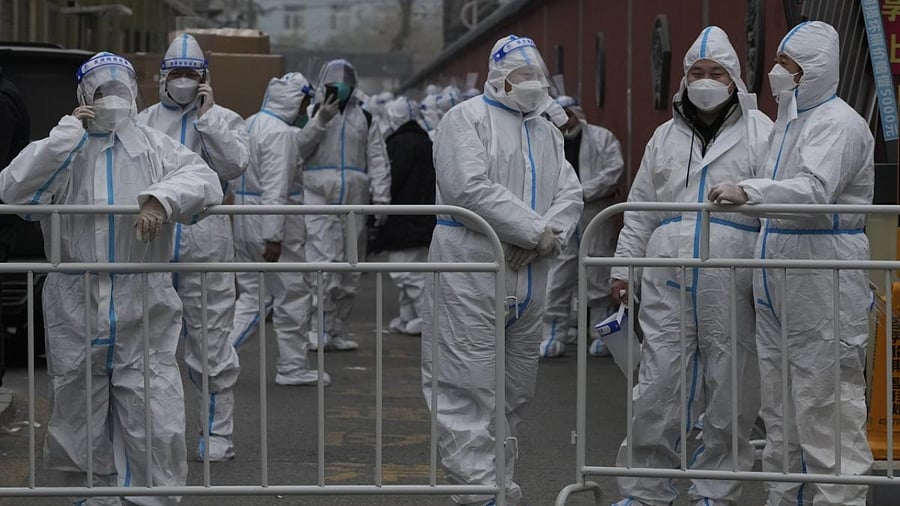 Workers in protective suits prepare their duties in a locked down neighborhood as part of Covid-19 controls in Beijing. Credit: AP/PTI Photo