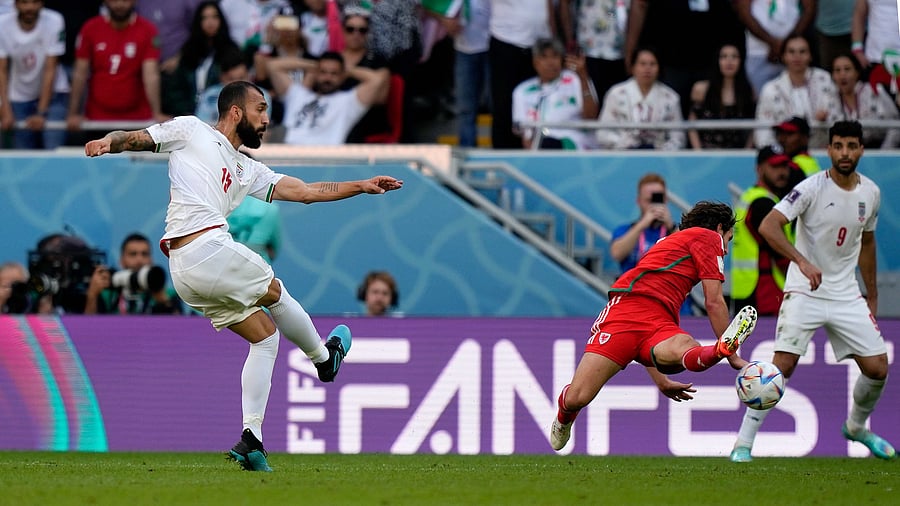 Rouzbeh Cheshmi shoots to score the first goal in overtime during the World Cup group B soccer match between Wales and Iran. Credit: AP/PTI Photo
