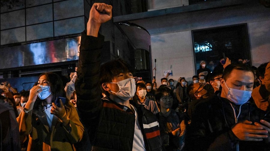 People sing slogans while gathering on a street in Shanghai. Credit: AFP Photo