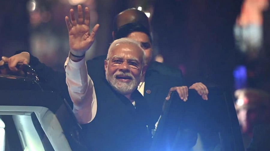 PM Narendra Modi waves at supporters during a roadshow in Surat ahead of assembly elections in Gujarat. Credit: PTI Photo