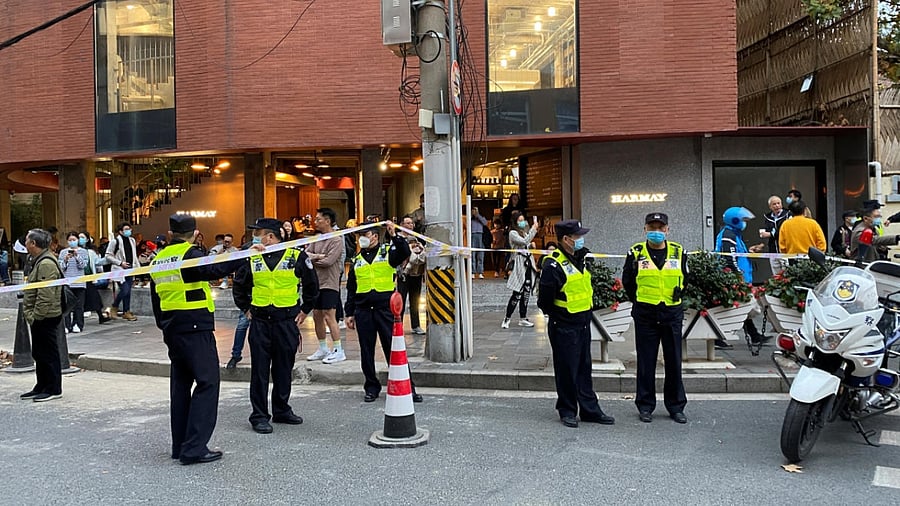 Police officers stand next to a cordon line set up near the site where a protest against COVID-19 curbs took place the night before, following the deadly Urumqi fire, in Shanghai, China November 27, 2022. Credit: Reuters Photo