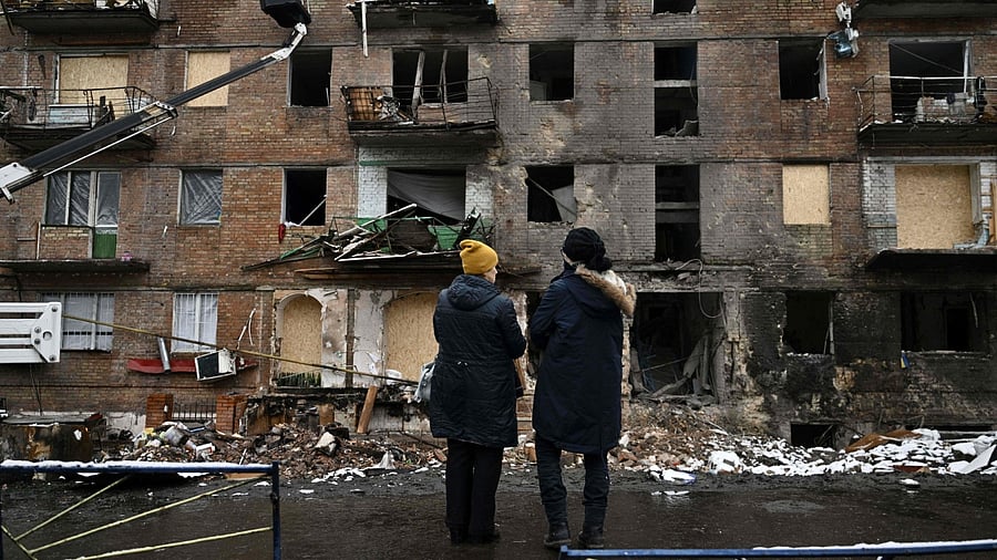 Local residents stand in front of a residential building damaged following a missile attack in Vyshgorod, outside of Kyiv on November 28, 2022, amid the Russian invasion of Ukraine. Credit: AFP Photo