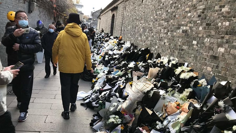 Flower bouquets placed by mourners are seen outside the old home of former Chinese leader Jiang Zemin, who passed away on November 30, in Yangzhou. Credit: AFP Photo