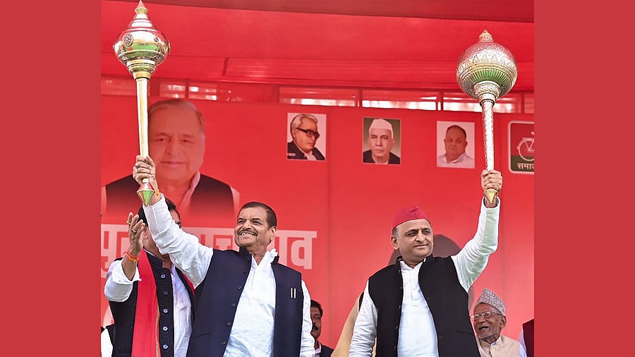 Samajwadi Party (SP) National President Akhilesh Yadav and Pragatisheel Samajwadi Party leader Shivpal Singh Yadav hold maces during a joint public meeting in support of SP’s candidate Dimple Yadav for the Mainpuri Lok Sabha by-election, in Jaswantnagar. Credit: Twitter/ @samajwadiparty