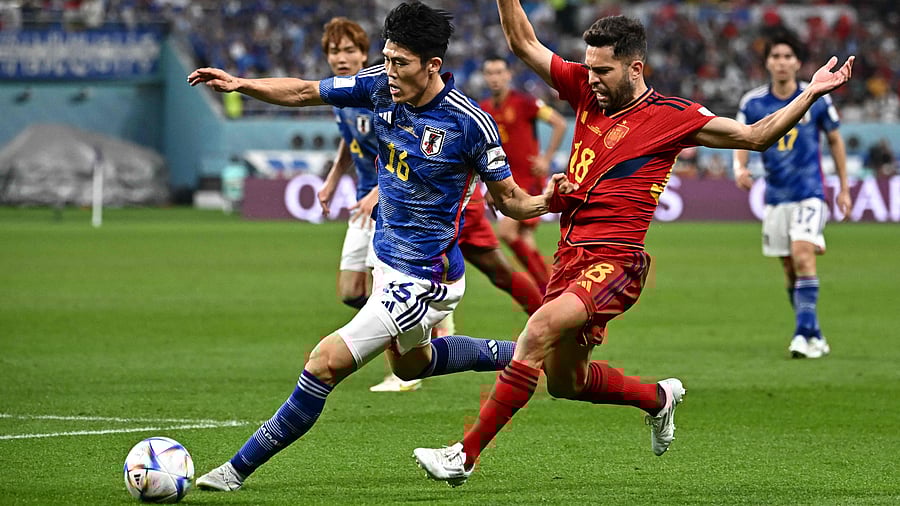 Takehiro Tomiyasu (L) and Jordi Alba (R) fight for the ball during the 2022 World Cup Group E football match between Japan and Spain at the Khalifa International Stadium in Doha on December 1, 2022. Credit: AFP Photo