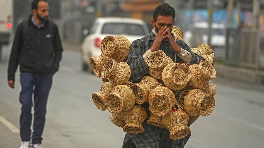 A vendor carries Kangri as he walks along a street in Srinagar. Credit: AFP Photo