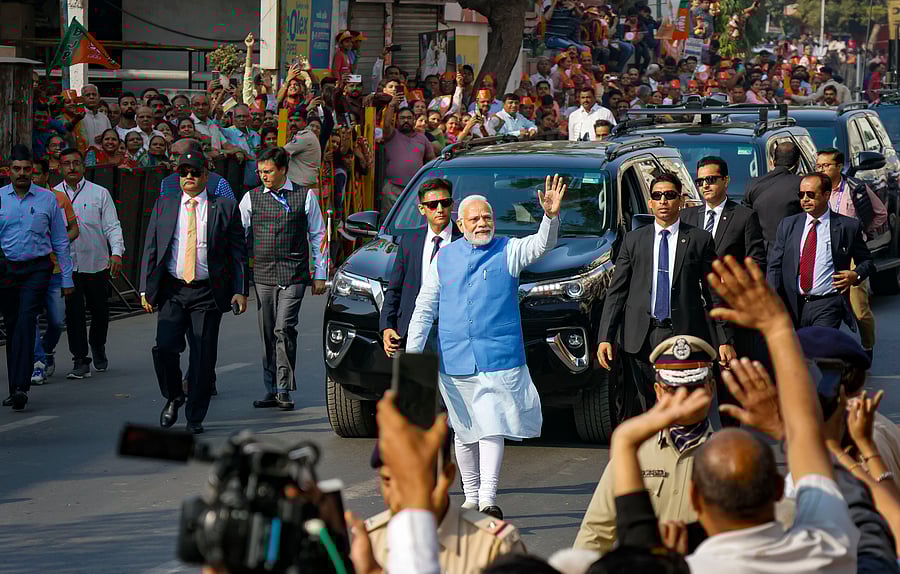 Prime Minister Narendra Modi waves at supporters as he leaves after casting his vote at a polling booth during the second and final phase of Gujarat Assembly elections, at Ranip area in Ahmedabad. Credit: PTI Photo