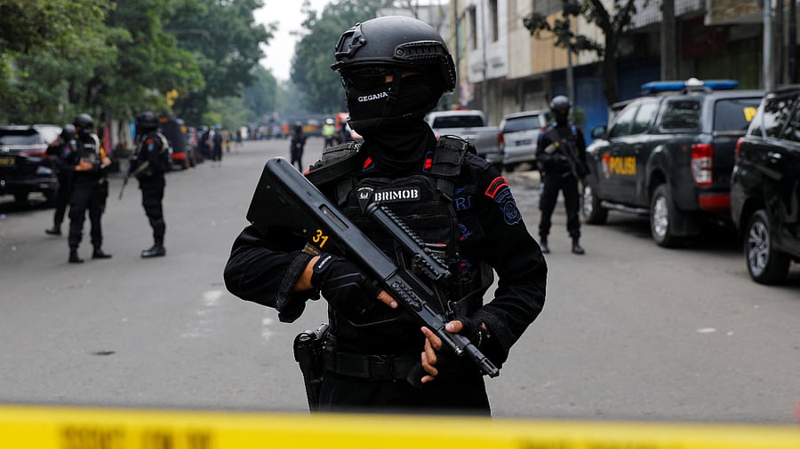 An armed police officer stands guard following a blast at a district police station, that according to authorities was a suspected suicide bombing, in Bandung, West Java province, Indonesia. Credit: Reuters Photo