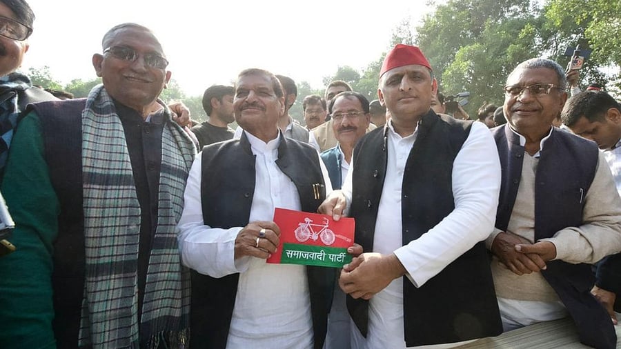 Akhilesh Yadav presents his party's flag to Shivpal Singh Yadav. Credit: Twitter/@samajwadiparty