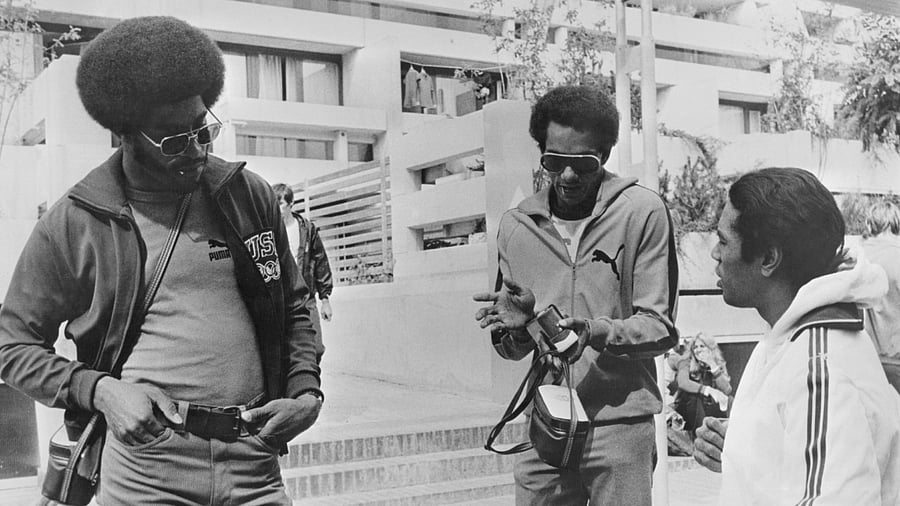 American sprinter John Smith, American sprinter Vince Matthews, and the Swiss team's doctor - and former American athlete - Dave James in conversation during the 1972 Summer Olympics. Credit: Getty Images