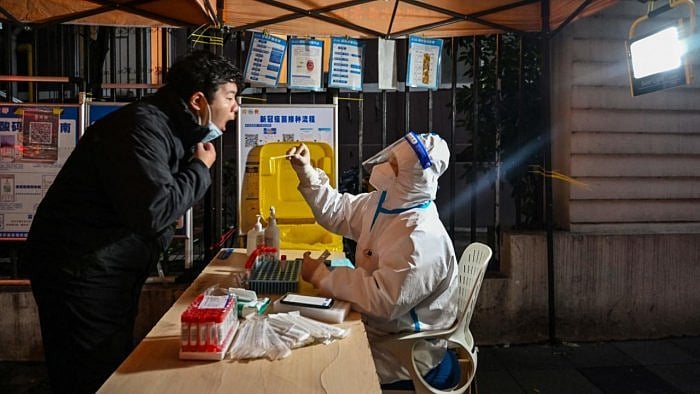 A health worker takes a swab sample from a man to test for the Covid-19 coronavirus in Shanghai. Credit: AFP Photo