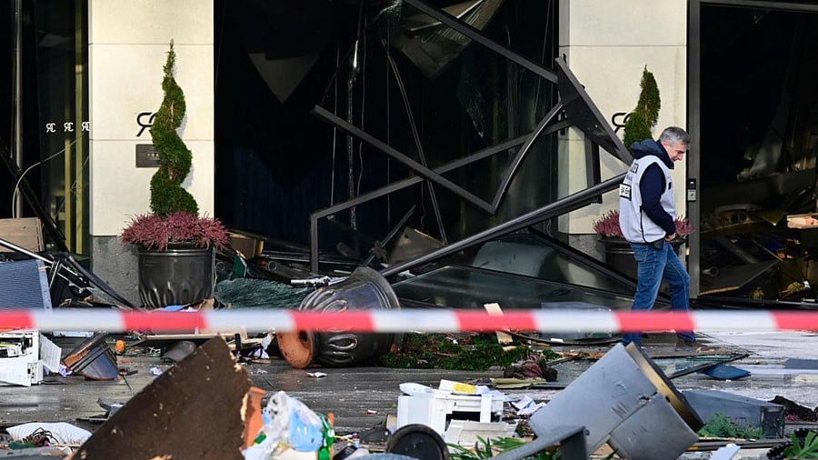 An investigator of the police walks past debris covering the street in front of the Radisson Blu hotel after a huge aquarium located in the hotel's lobby burst on December 16, 2022 in Berlin. Credit: AFP Photo