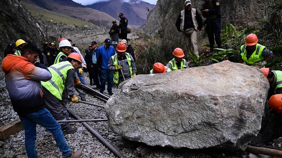 Workers attempt to remove a rock placed by rioters on the railway track to block the train's passage to and from the Inca citadel of Machu Picchu in Peru. Credit: AFP Photo