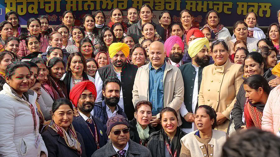 Bhagwant Mann along with Manish Sisodia poses for a group photo during the Parent-Teacher Meeting. Credit: PTI Photo