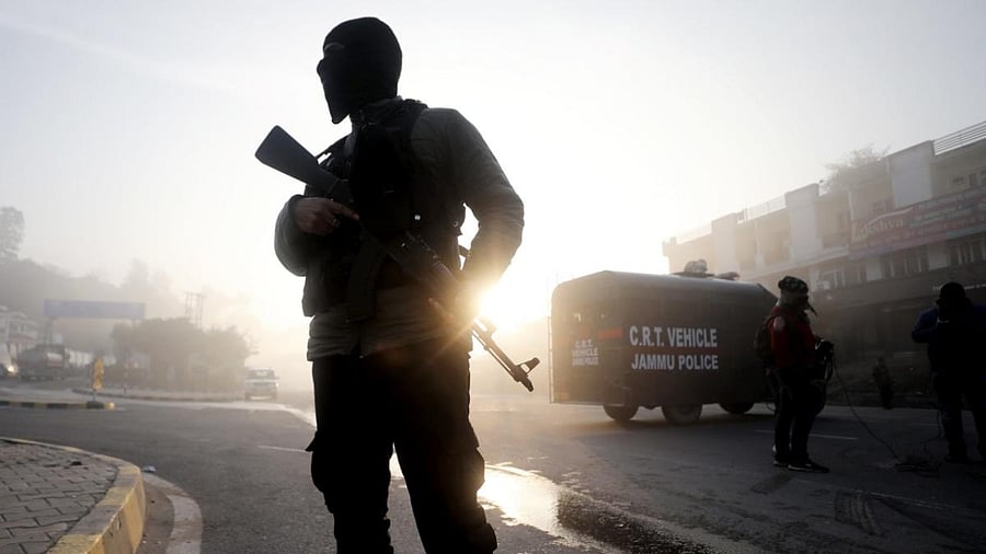 A Crises Response Team (CRT) personnel stands guard at Jammu Kashmir National Highway, near the spot of the encounter between terrorists and security forces in the Sidhra area. Credit: PTI Photo