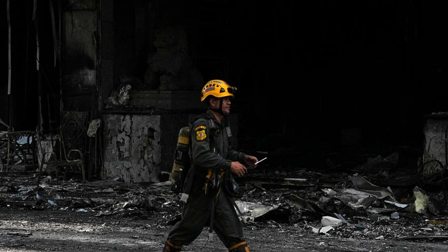 A rescue worker walks in front of the Grand Diamond City hotel-casino where a fire broke out, in Poipet near Thailand border, Cambodia, December 30, 2022. Credit: Reuters Photo