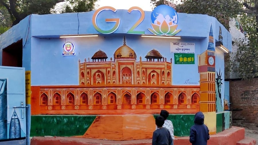 Children watch a mural created on the walls of a dump yard as part of preparedness for the G20 Summit. Credit: PTI Photo