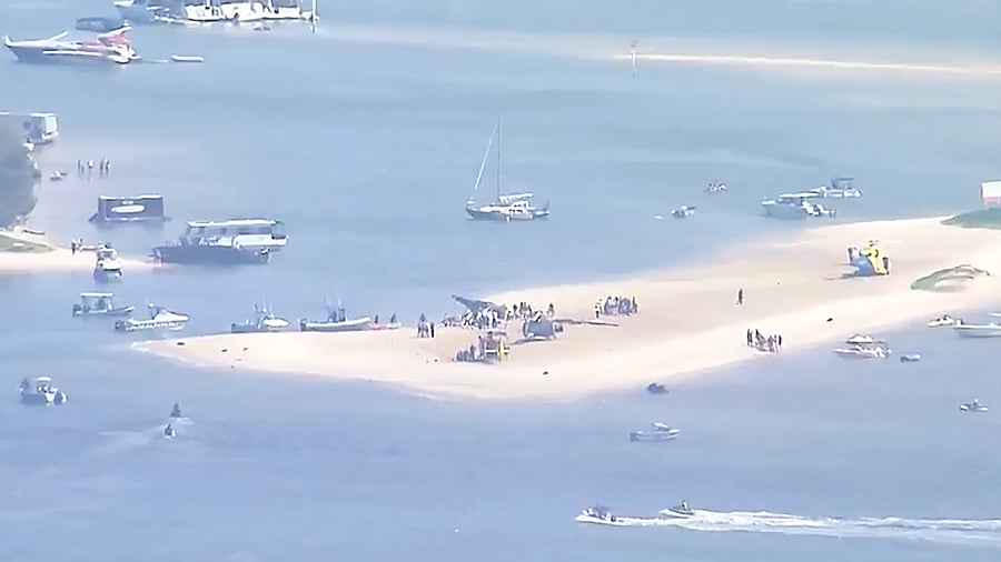 This image made from a video shows sand bank with crashed helicopter on Gold Coast, Australia. Credit: AP Photo