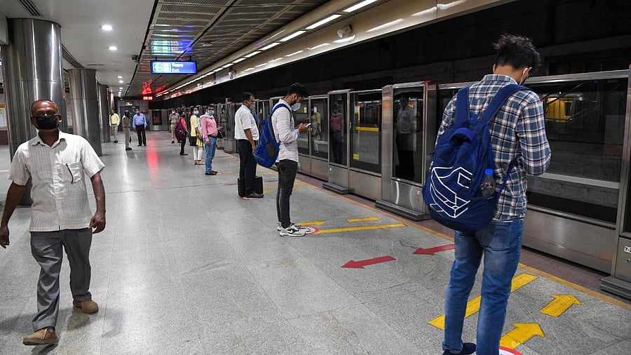 Commuters wait for a Yellow Line train in a metro station in Delhi. Credit: AFP File Photo