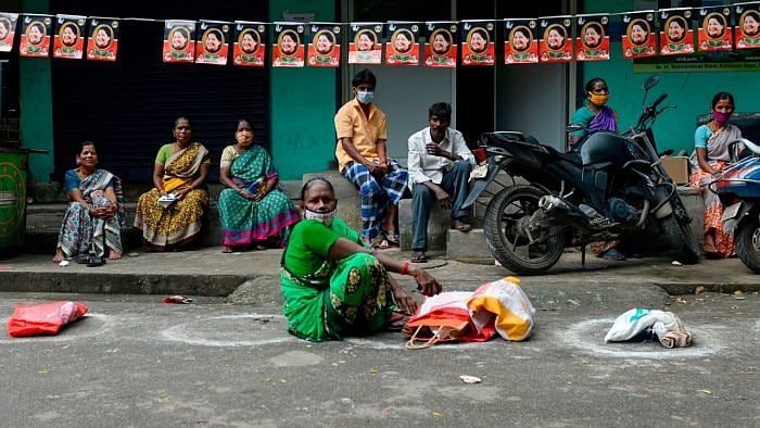 Residents wait in front of a government fair price ration shop to collect free gift hampers on the occasion of the harvest festival of 'Pongal' in Chennai on January 4, 2021. Credit: AFP File Photo