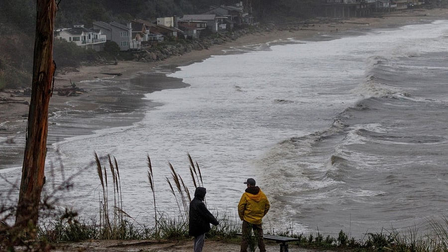 Local residents walk along the coastal line near Santa Cruz as rainstorms approach northern California. Credit: Reuters Photo