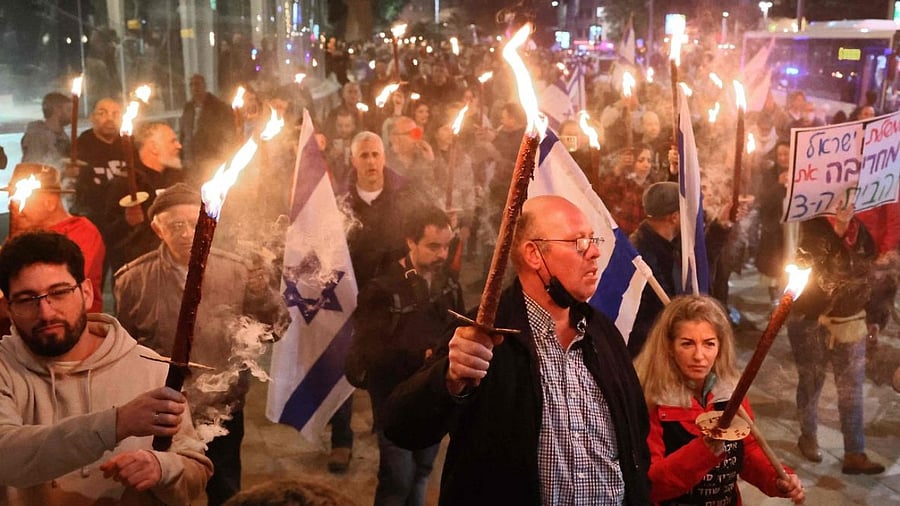 Israeli left wing protesters march with torches during a rally against Netanyahu's new hard-right government. Credit: AFP Photo