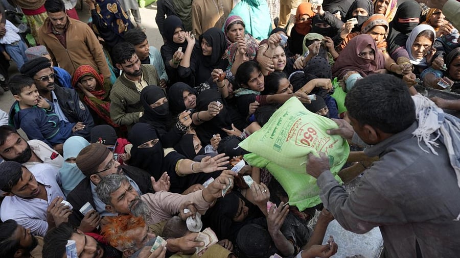Pakistani people gather to buy subsidized sacks of flour from a sale point in Karachi, Pakistan. Credit: AP/PTI Photo
