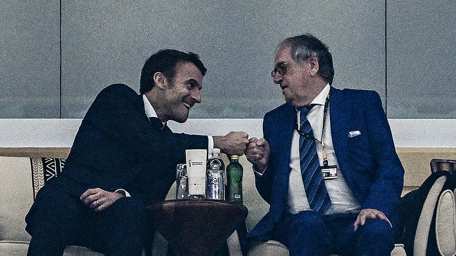 French President Emmanuel Macron (L) bumps fists with the president of the French Football Federation, Noël Le Graët. Credit: AFP File Photo