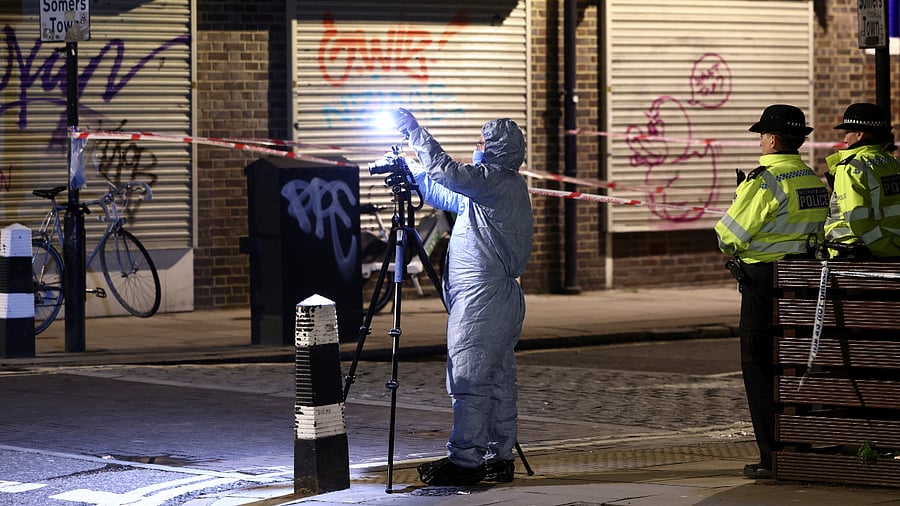 Forensics officer works at the scene of a shooting, the attack reportedly happened during a funeral at St Aloysius Church, in London. Credit: Reuters Photo