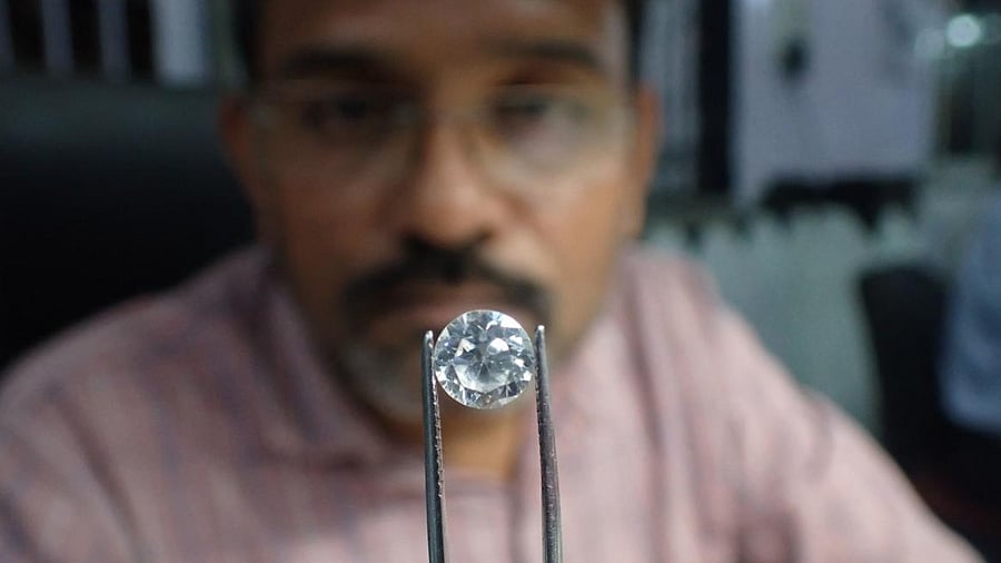 A worker checks a diamond at a diamond polishing workshop in Ahmedabad. Credit: AFP File Photo